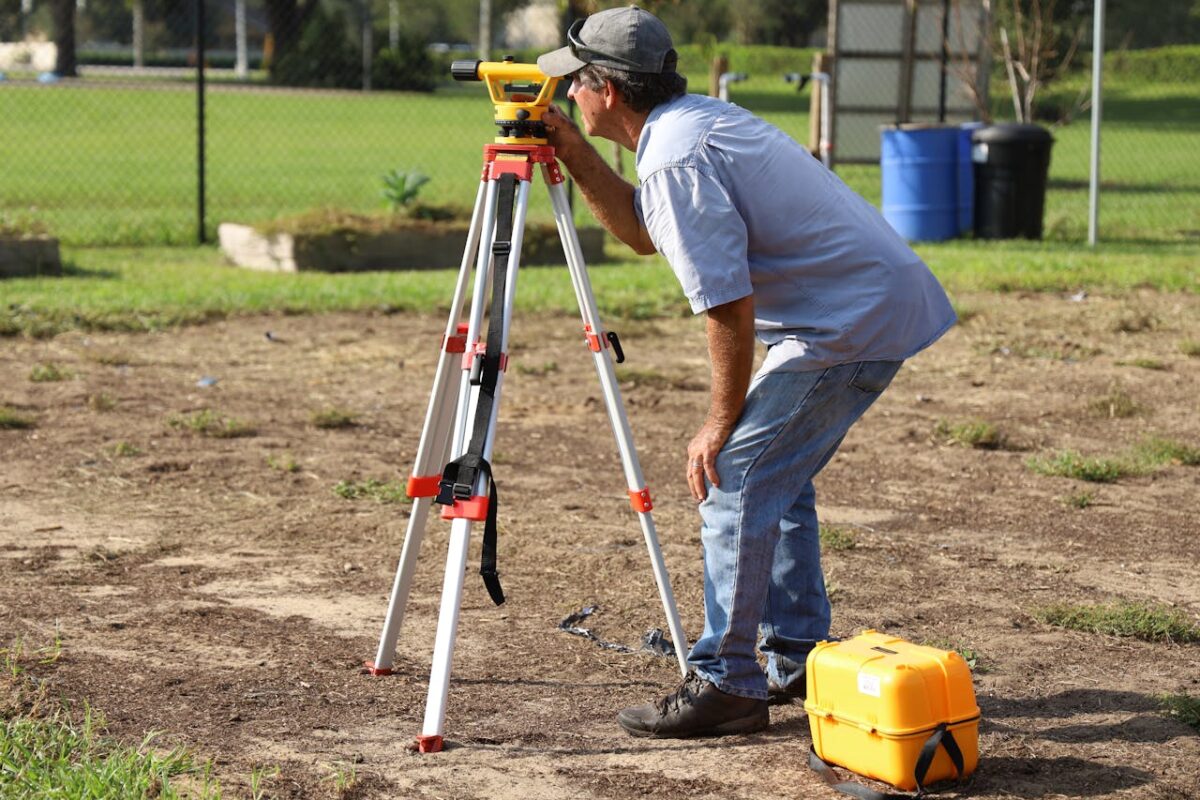 A land surveyor at work using equipment on a field in Tavares, Florida.